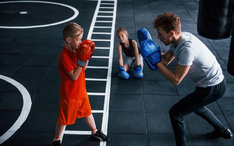 young-trainer-teaches-kids-boxing-sport-in-the-gym.jpg